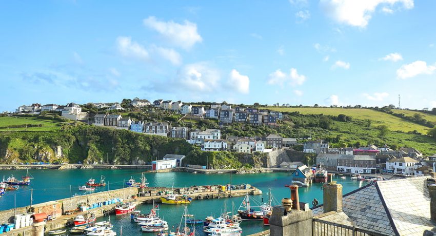 Mevagissey, Cornwall, England / UK - July 5, 2020: View of Mevagissey Harbour on a sunny Summer day with colourful fishing boat. Cornwall, UK