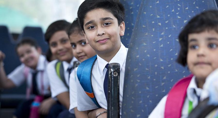 School children traveling in school bus looking at camera